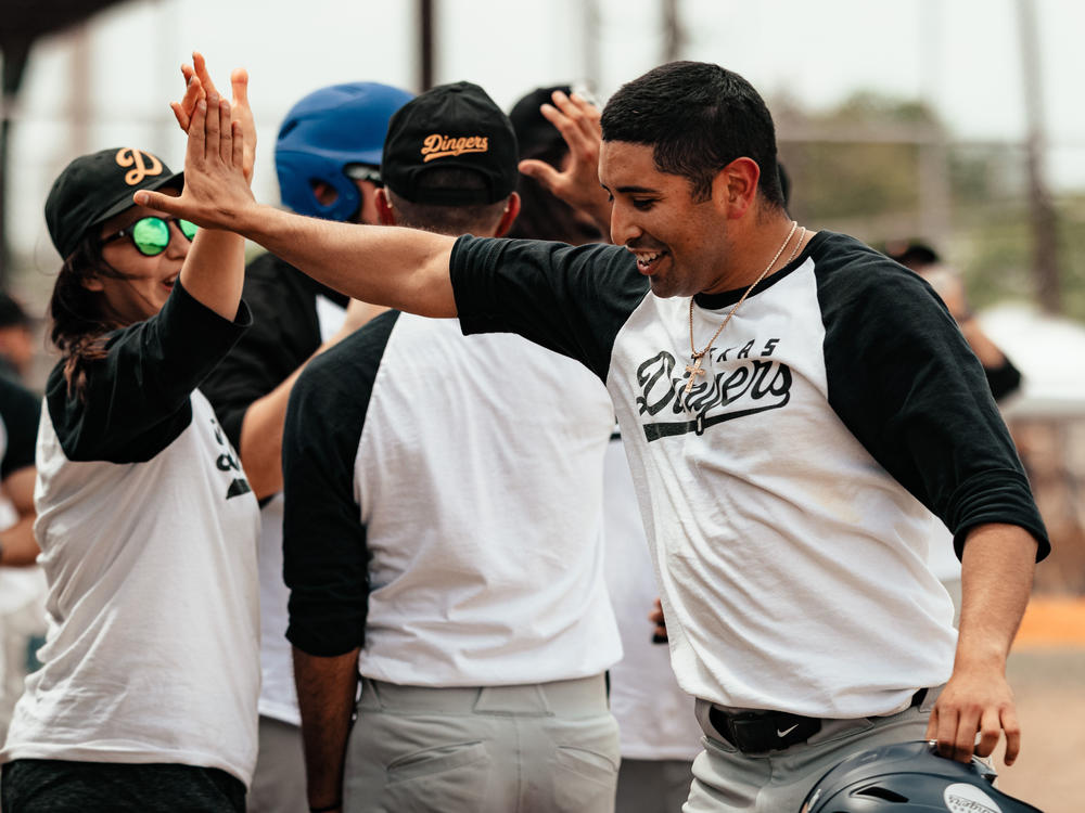 The Dingers' Matthew Carrillo shares a high five with a teammate.