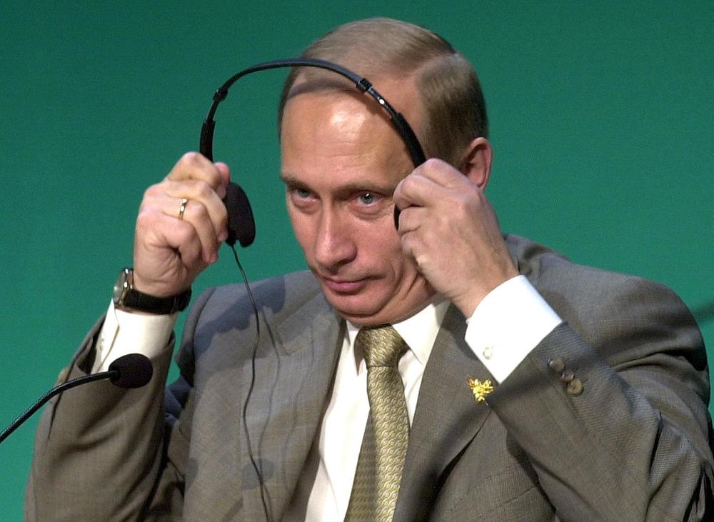 Russian President Vladimir Putin puts on his headset to listen to questions from delegates at a business forum on the side of the Asia-Pacific Economic Cooperation (APEC) summit in Bandar Seri Begawan, Brunei, on Nov. 15, 2000.