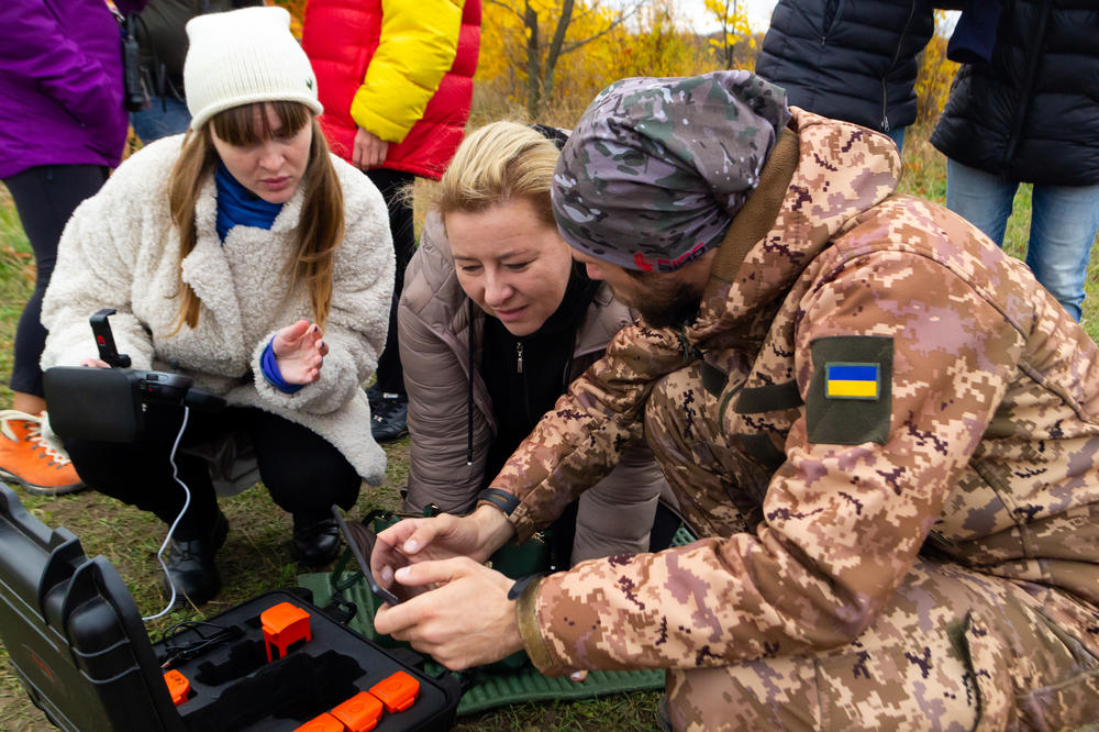 Mykyta Kosov, right, an instructor in the drone school, shows Tatiana Nikolaienko, left, and Yevhenia Podvoiska, center, how to plan a course for their drone to gather reconnaissance and evade detection in Kyivon Oct. 27.