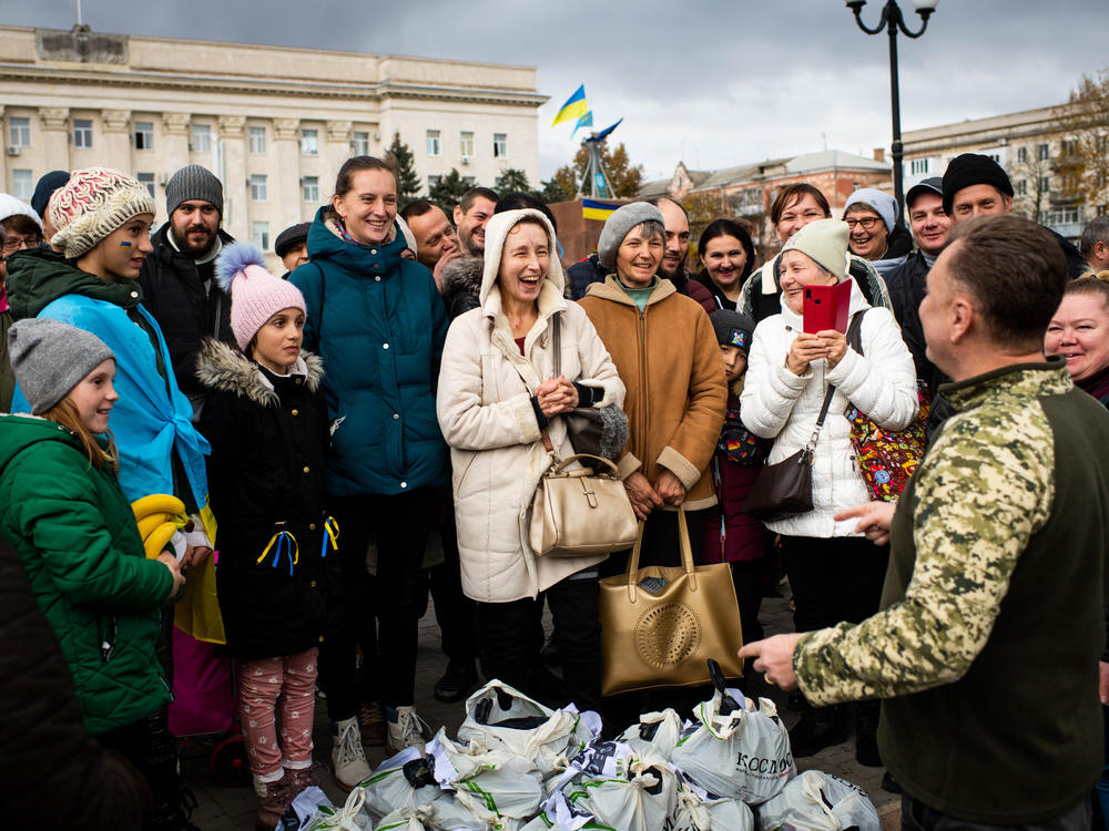 Local people react to a volunteer from Odesa distributing aid on the main square in front of the Regional Administration Building in Kherson on Wednesday.