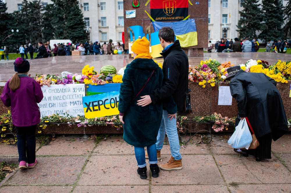 People visit a makeshift monument on the central square of recently liberated Kherson on Wednesday.