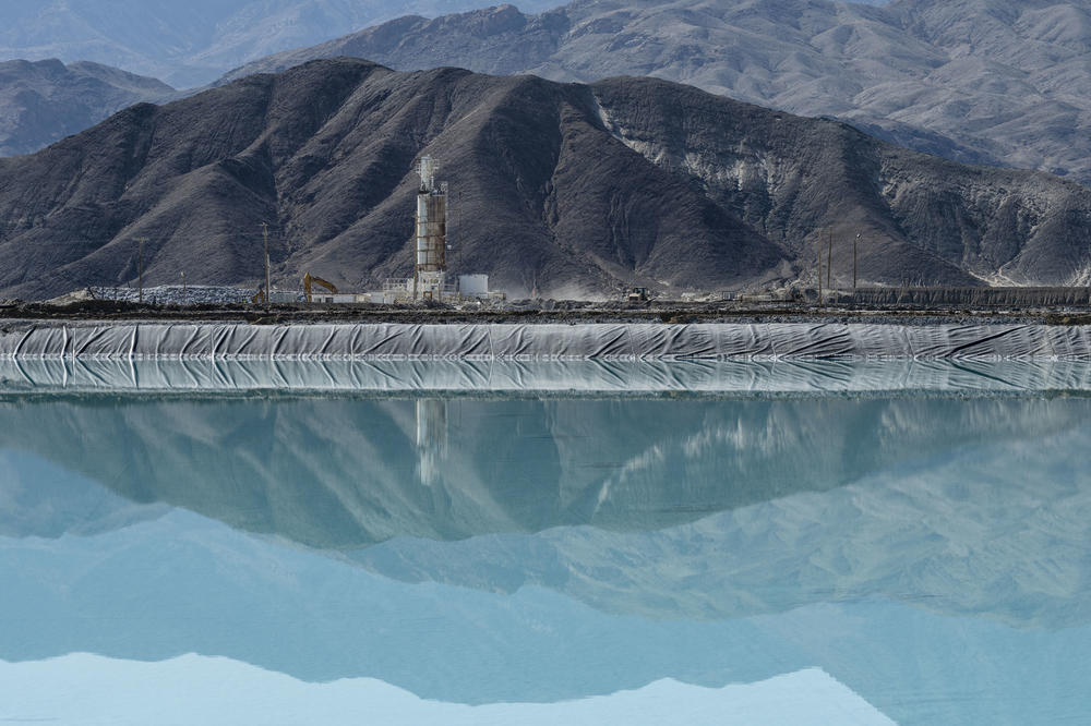 The mountains are reflected in a lithium brine evaporation pool at Silver Peak lithium mine in Silver Peak, Nev. on Oct. 6, 2022.