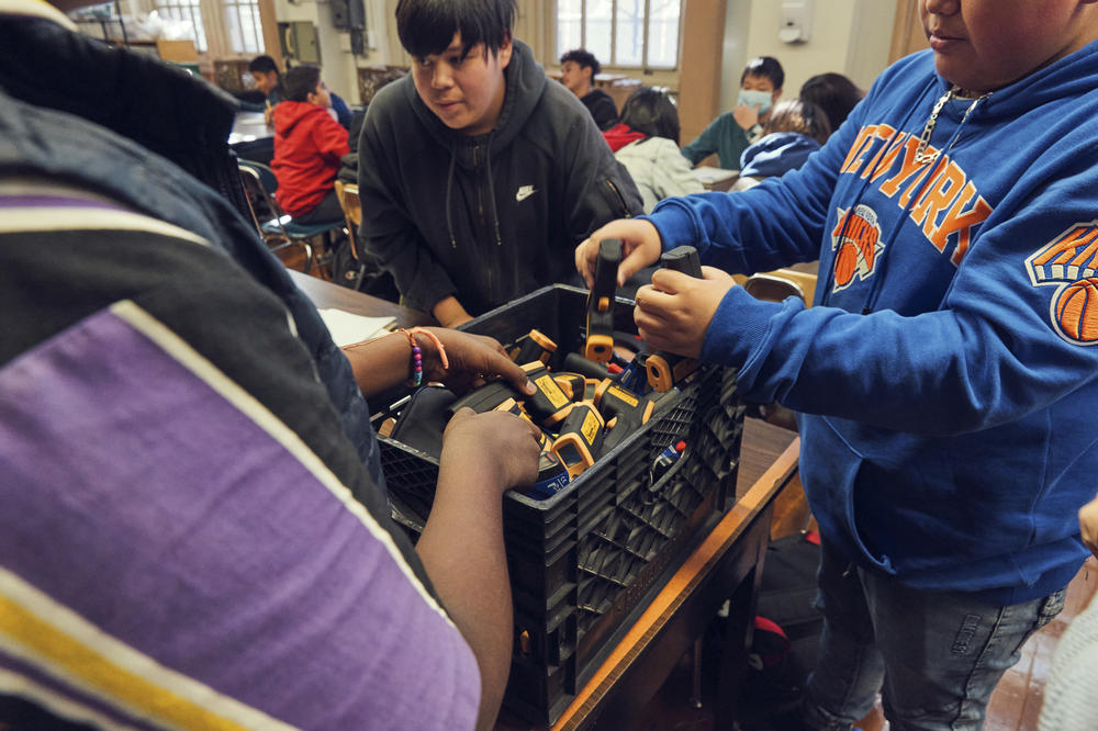 Slack's students use handheld digital thermometers to measure temperatures around their school playground.