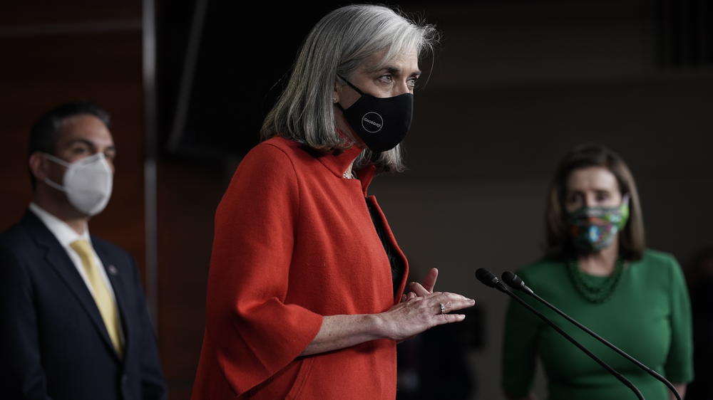 Rep. Katherine Clark, D-Mass., meets with reporters before the House votes to pass a $1.9 trillion pandemic relief package in 2021. Speaker of the House Nancy Pelosi, D-Calif., right, and Rep. Pete Aguilar, D-Calif., listen.