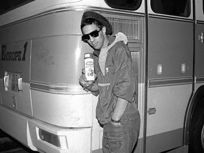 Futura 2000 in front of the 'New York City Rap Tour' bus London, 1982 © Janette Beckman.