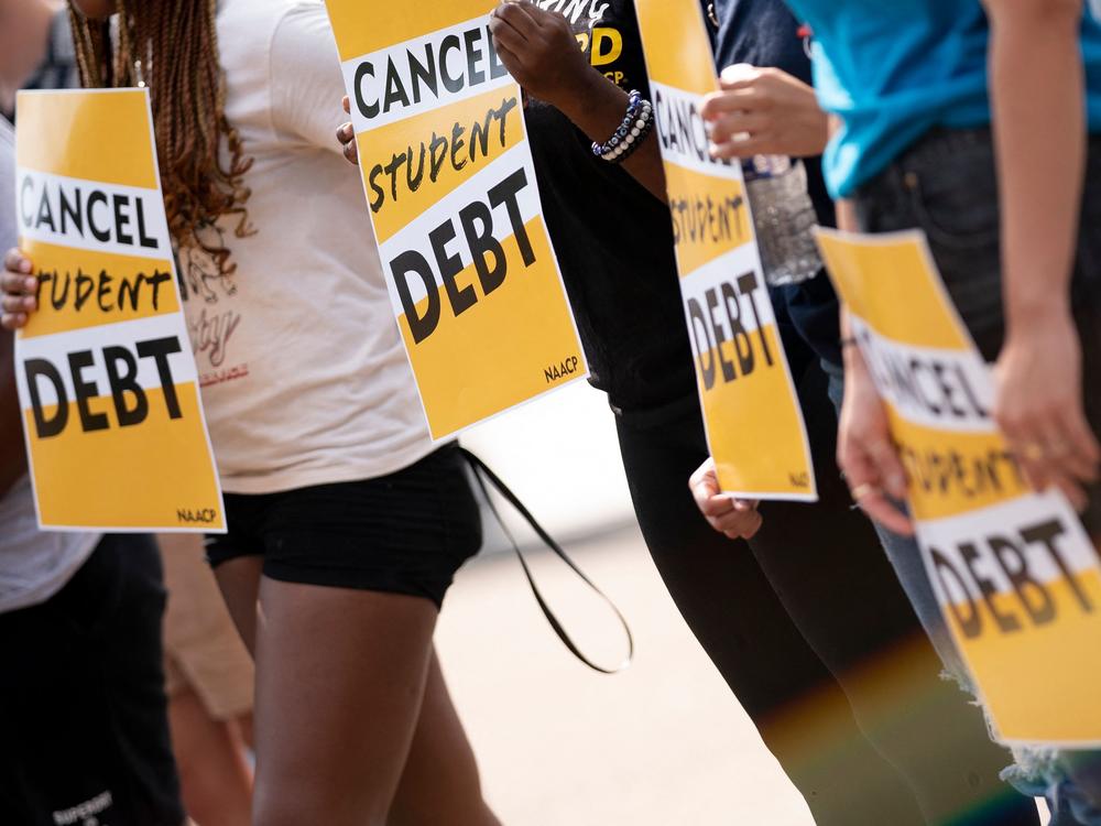 Activists hold cancel student debt signs as they gather to rally in front of the White House in Washington, D.C., on Aug. 25.