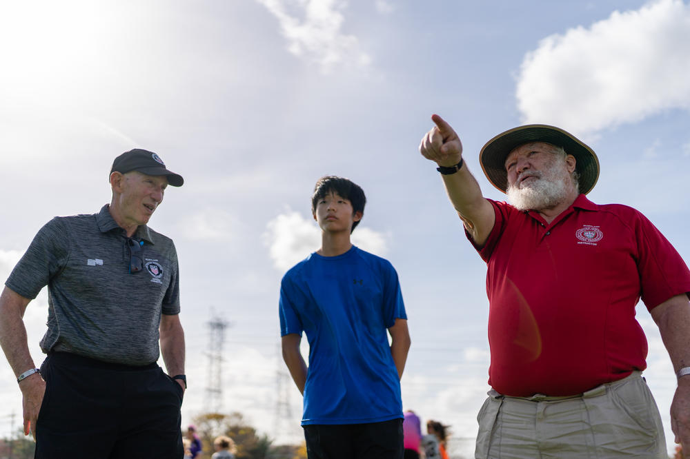 Larry Mittleman (left), state director of instruction for Maryland Soccer Referees, and Peter Guthrie instruct Jason Kim, 14, a new referee after a youth soccer match at Maryland SoccerPlex.