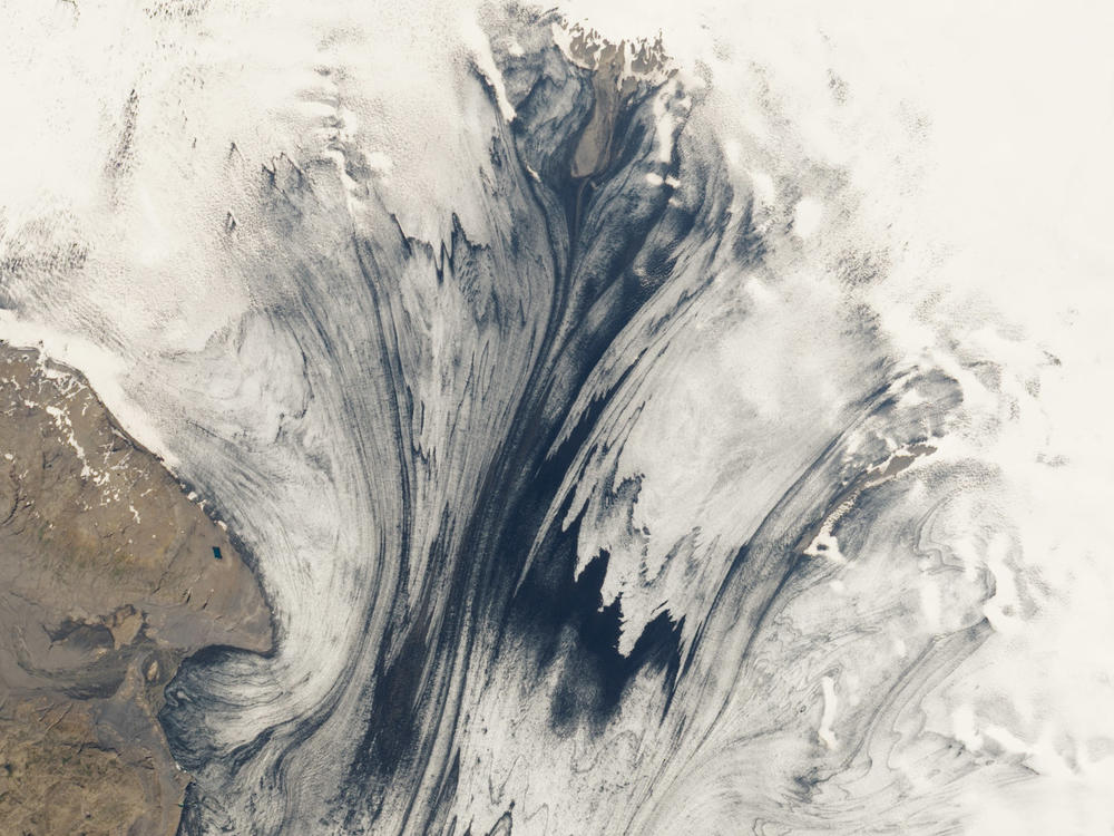 Glaciers and volcanoes frequently interact in Iceland — a relationship that's rare elsewhere on Earth. This satellite image from NASA shows a glacier in Iceland's Vatnajökull National Park, with volcanic ash embedded within it.