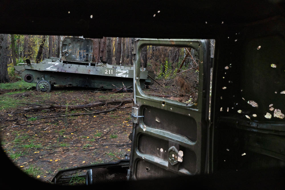 Abandonded vehicles with Russian markings are filled with holes in the woods in Izium in October.