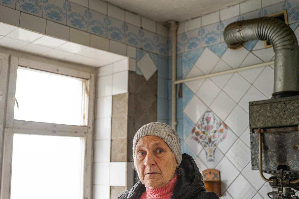 Halyna Zahorodnikh, 71, stands in her kitchen that, like much of her apartment, has sustained damage from nearby shelling. Plastic sheets now hang where the windows were. She is one of millions of Ukrainians facing a winter that's essentially being weaponized against them.