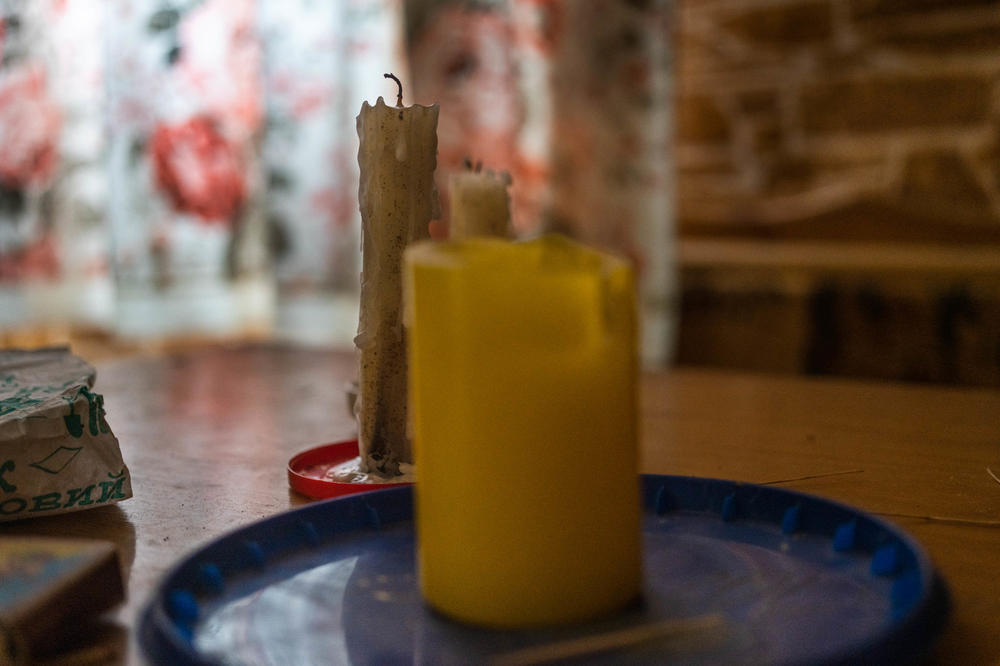 Candles sit on the table in Voinov's home. With the power out, he and other residents live by wood heat and candle light.
