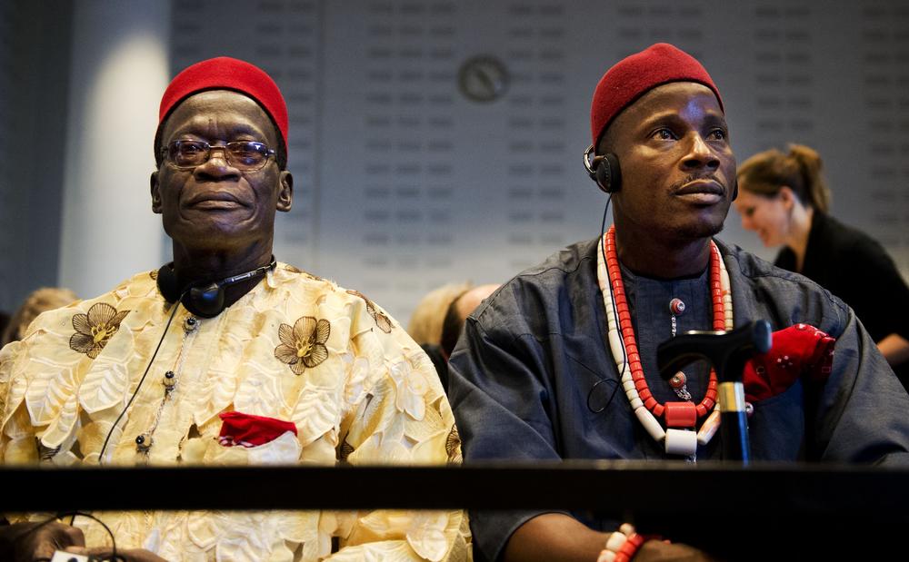 Two of the four Nigerian farmers who were part of a lawsuit against Shell over an oil spill from a Shell subsidiary that devastated their village. Left to right: Chief Fidelis A. Oguru-Oruma and Eric Dooh, sitting in the law courts in The Hague, where the trial was held.