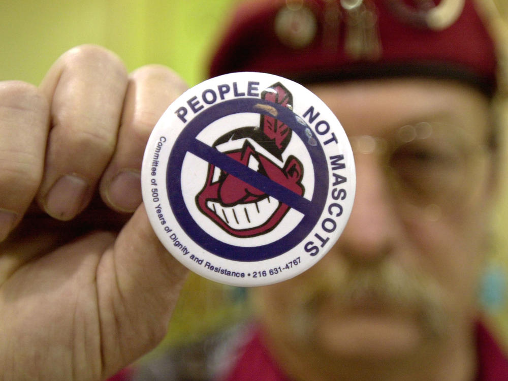 Powwow attendee Sonny Hensley holds an anti-mascot button to protest using Indians as mascots for sports teams at the 2003 New Years Eve Sobriety Powwow in Columbus, Ohio.