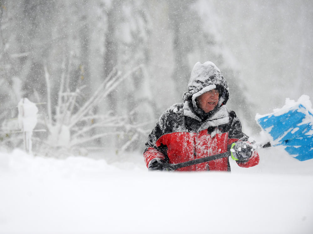 Tom Dee uses a shovel to dig out after an intense lake effect snowstorm impacted the area on Friday in Hamburg, N.Y.