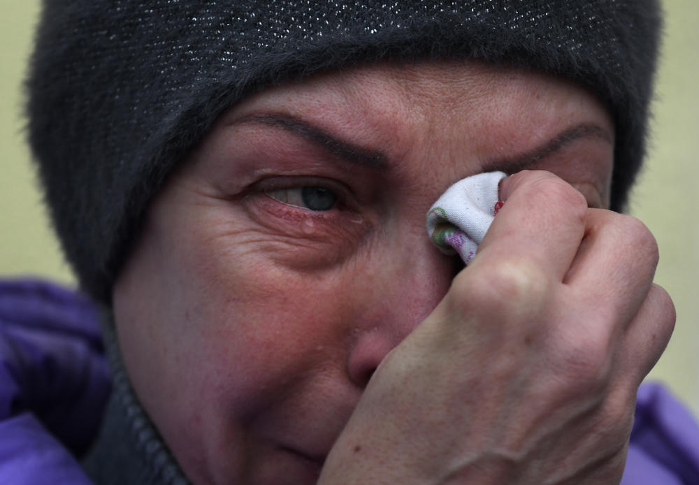 Elena weeps as she listens to Ukrainian musical performers after the first train arrives in Kherson on Saturday.