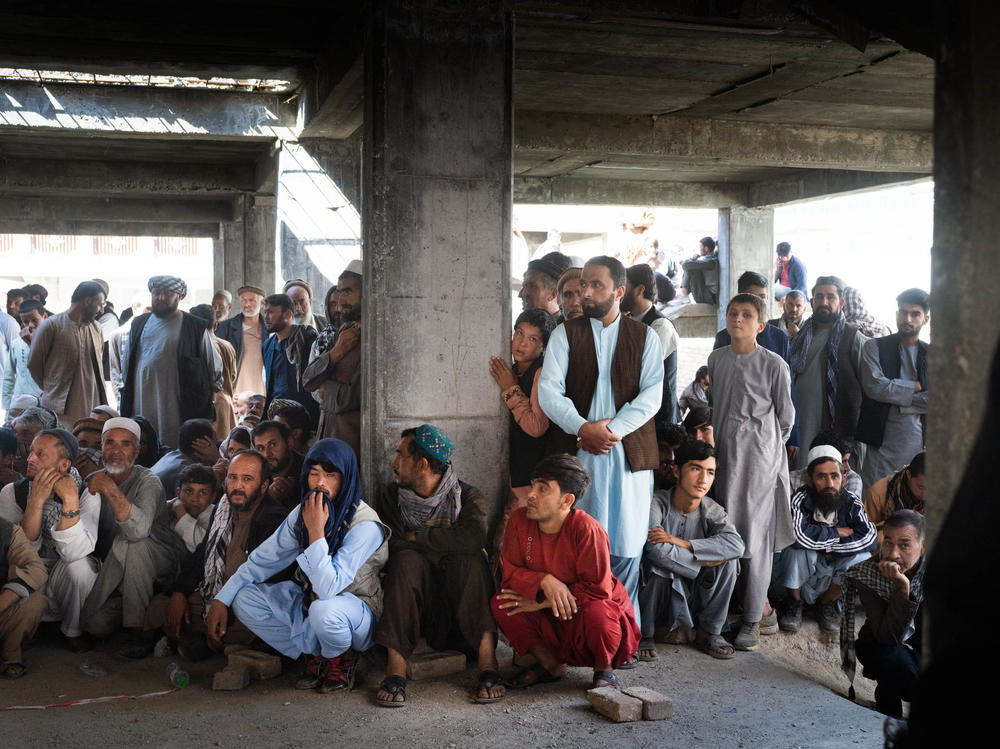 Afghans wait for food assistance from the World Food Programme in Kabul in October.