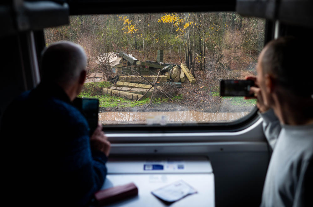 Passengers film ammunition boxes and other evidence of war from the train.