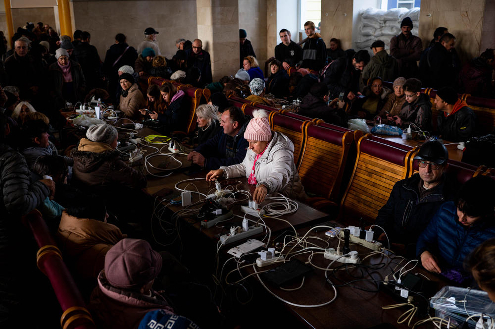 People use one of the train station halls in Kherson as a charging station for their phones and other devices. Basic services including water, heat and internet connectivity are essentially nonexistent in the city.