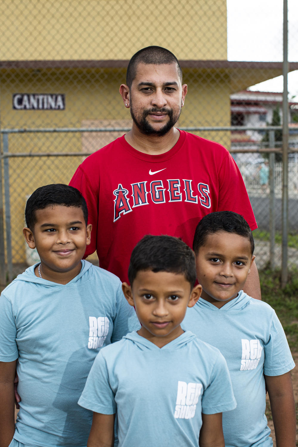 Carlos Rodríguez Malavé with his sons Jahxiel, Ian and Isaac. Before Hurricane Fiona damaged their neighborhood ballpark in September, Rodríguez had formed a league for children. He was one of the coaches.