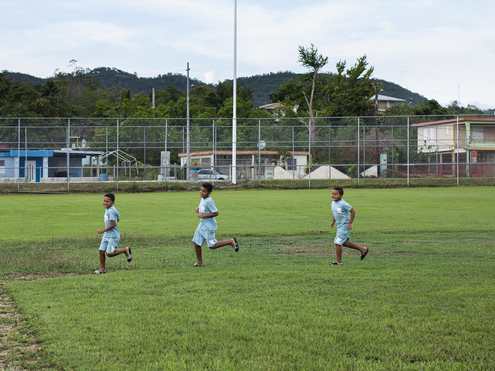 Brothers Ian, Jahxiel and Isaac RodrÃÂ­guez run the bases at the damaged baseball park in their neighborhood, Lajas Arriba, in Lajas, Puerto Rico.