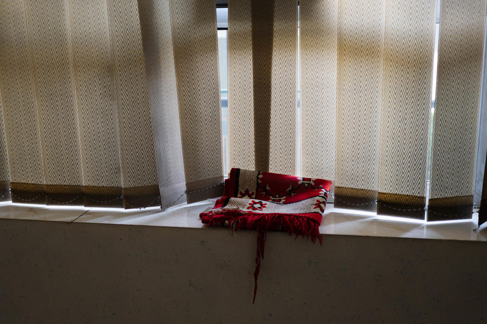 A prayer rug sits on a window sill in a location where the ex-commando sometimes stays.