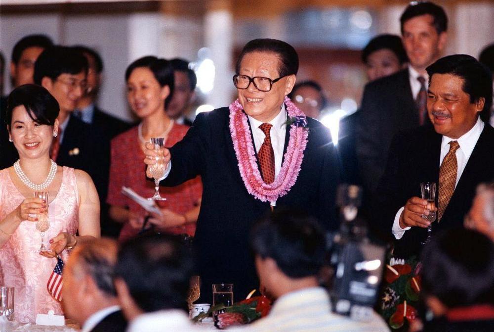 China's President Jiang Zemin raises his glass in a toast during a state dinner held in Honolulu, Hawaii, on Oct. 26, 1997. The dinner was hosted by Hawaii Gov. Benjamin Cayetano (right) and his wife Vicky Cayetano (left).