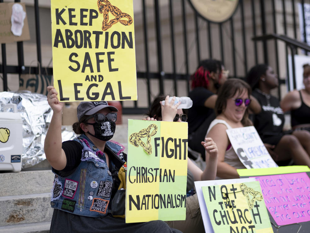 A small group, including Stephanie Batchelor, left, sits on the steps of the Georgia state Capitol protesting the overturning of Roe v. Wade on June 26, 2022. The Georgia Supreme Court on Wednesday, Nov. 23, reinstated the state's ban on abortions after roughly six weeks of pregnancy.