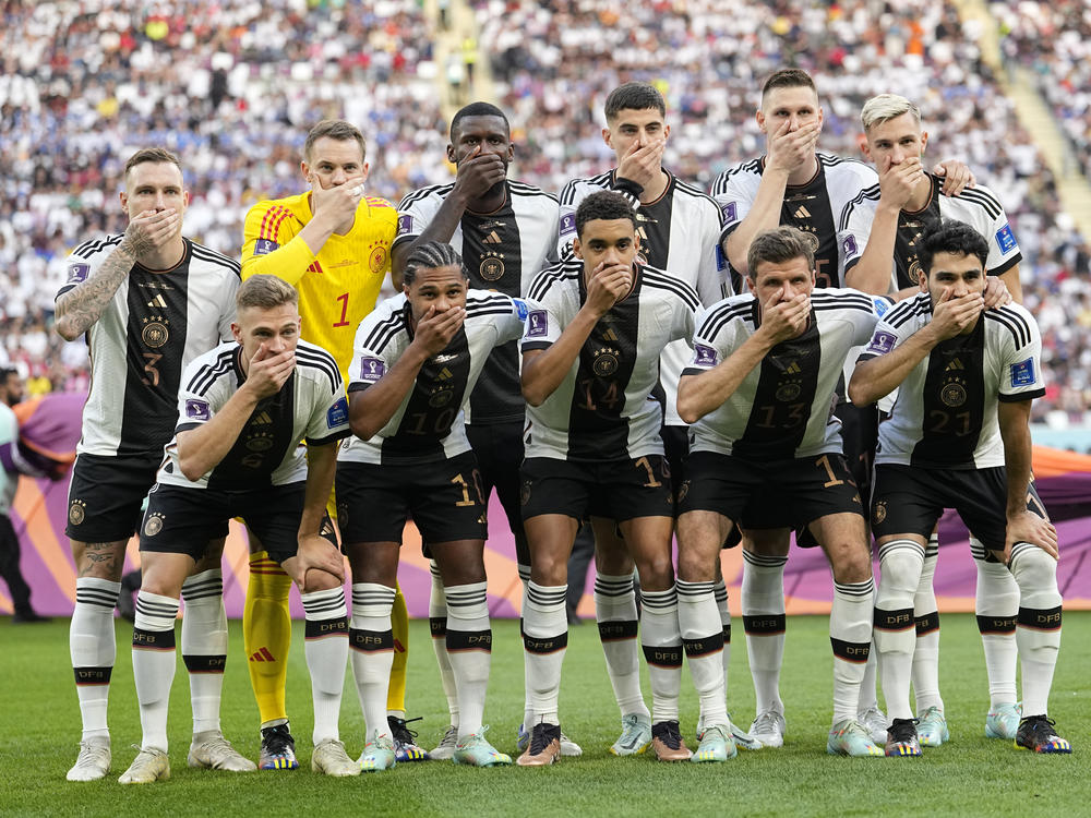 Players from Germany pose for the team photo as they cover their mouth during the World Cup group E soccer match between Germany and Japan on Wednesday.