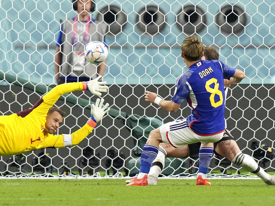 Japan's Ritsu Doan scores his side's first goal Wednesday against Germany's goalkeeper Manuel Neuer during a World Cup soccer match at the Khalifa International Stadium in Doha, Qatar.