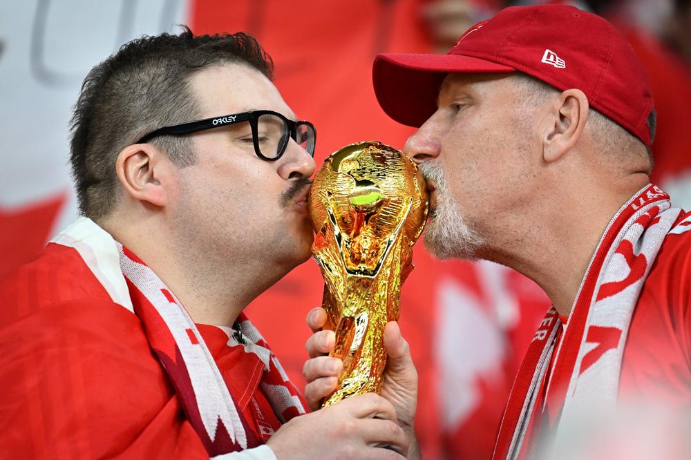 Canadian fans kiss a World Cup trophy during a2022 FIFA World Cup Group F match with Belgium at the Ahmad Bin Ali Stadium on Wednesday, Nov. 23, 2022, in Doha, Qatar.