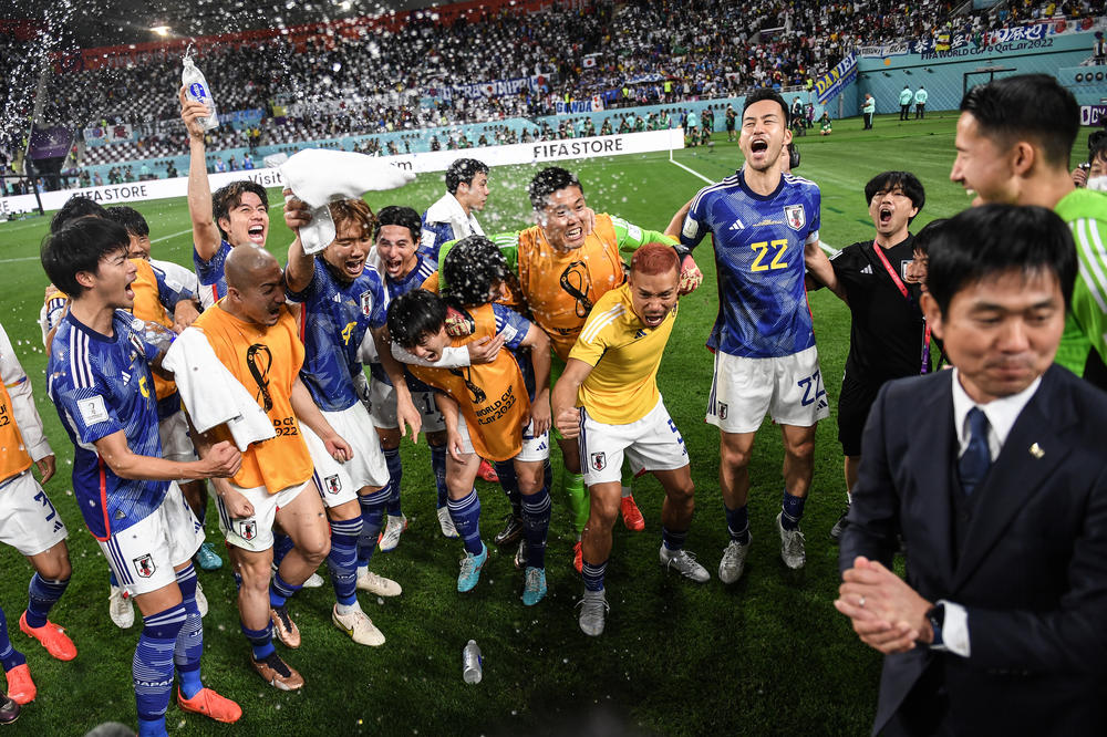 Japan's players celebrate a 2-1 win in their 2022 FIFA World Cup Group E match with Germany at the Khalifa International Stadium on Wednesday, Nov. 23, 2022.