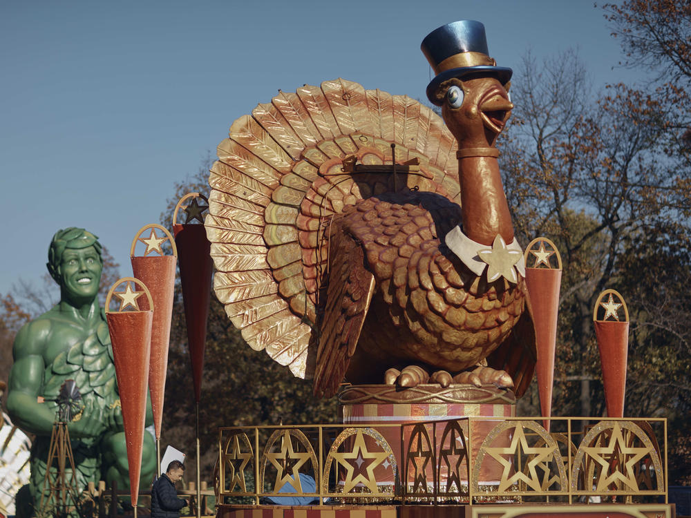 A man inspects a float of Tom Turkey that is lined up for the Macy's Thanksgiving Day Parade.