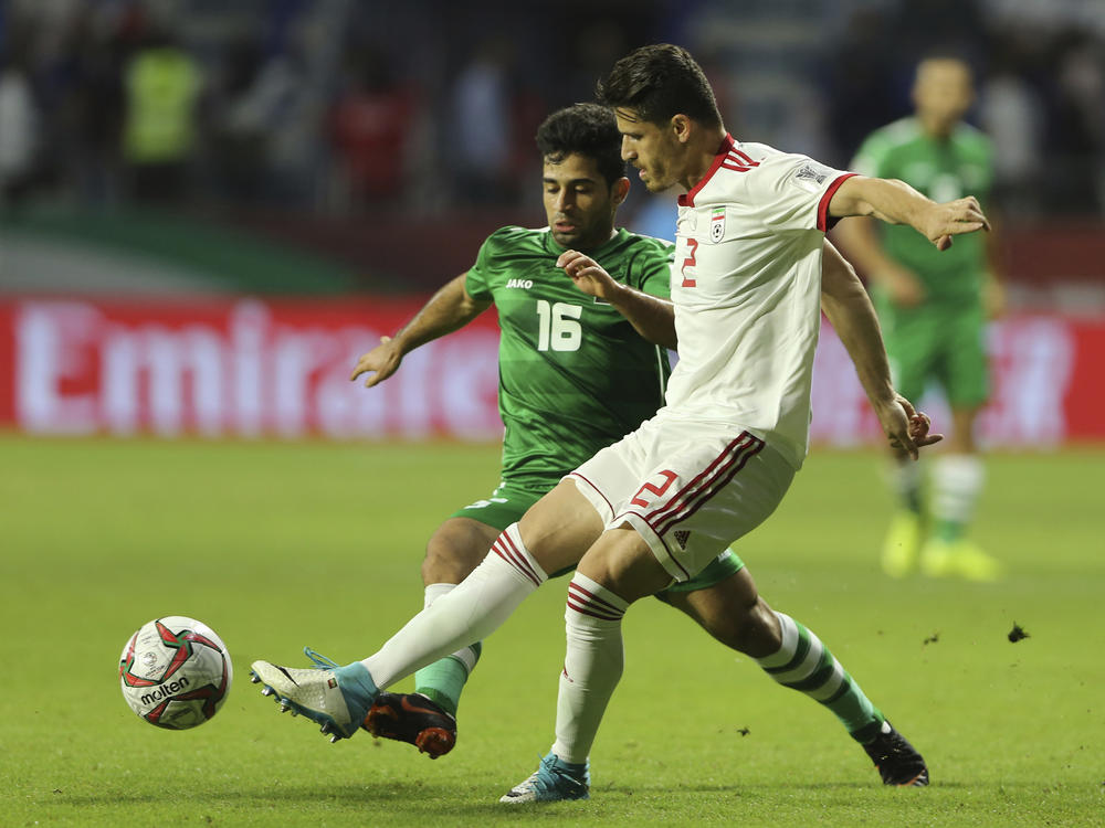 Iranian soccer player Voria Ghafouri (right), then a member of the national soccer team, fights for the ball with Iraqi midfielder Hussein Ali during the AFC Asian Cup soccer match in Dubai in 2019. The semiofficial Fars and Tasnim news agencies reported on Thursday that Iran arrested Ghafouri for insulting the national soccer team and criticizing the government.