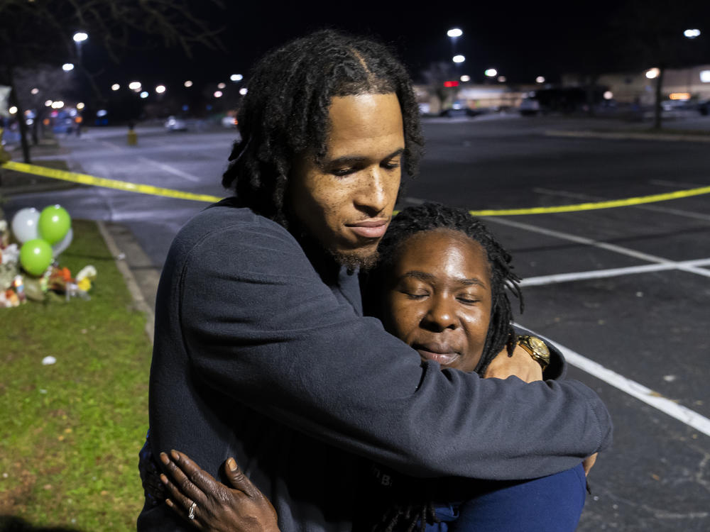 Cameron Bertrand hugs LaShana Hicks at a Tuesday memorial for those killed in a fatal shooting at a Walmart Supercenter in Chesapeake, Va.