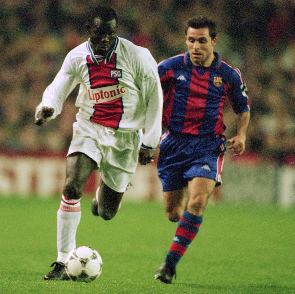 George Weah of Paris St Germain charges past Sergi of Barcelona in 1995 during the European Cup quarterfinals in Barcelona, Spain.