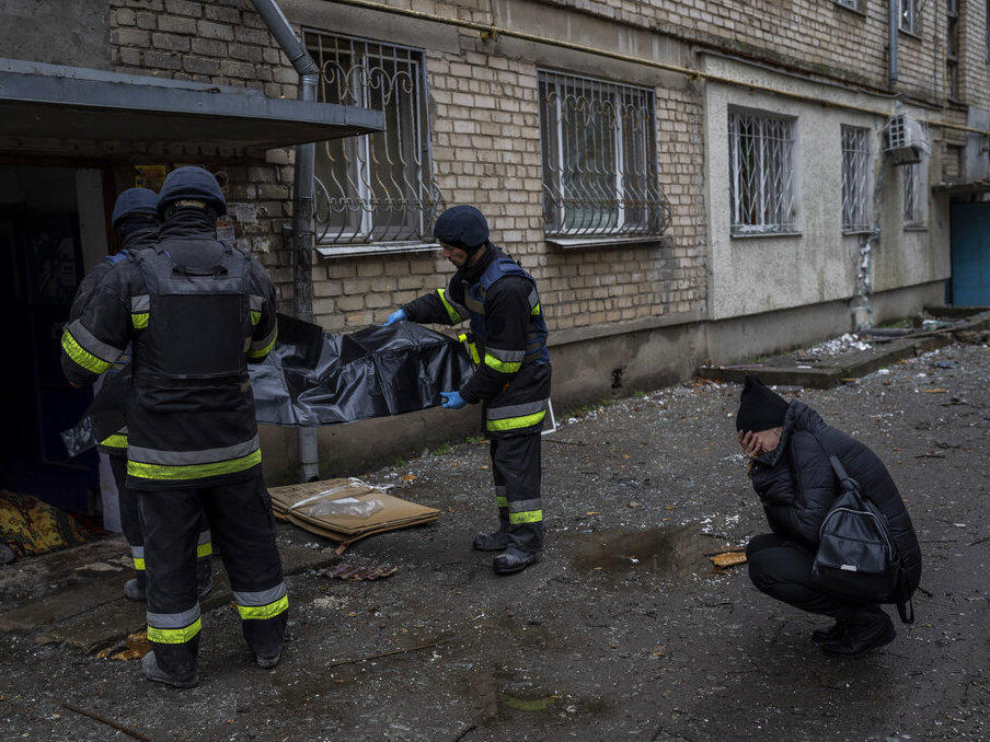 Lilia Kristenko, 38, cries Friday as city responders collect the dead body of her mother Natalia Kristenko in Kherson, southern Ukraine. Natalia Kristenko's dead body lay covered in a blanket in the doorway of her apartment building for hours overnight. The 62-year-old woman had walked outside her home with her husband Thursday evening after drinking tea when the building was struck.