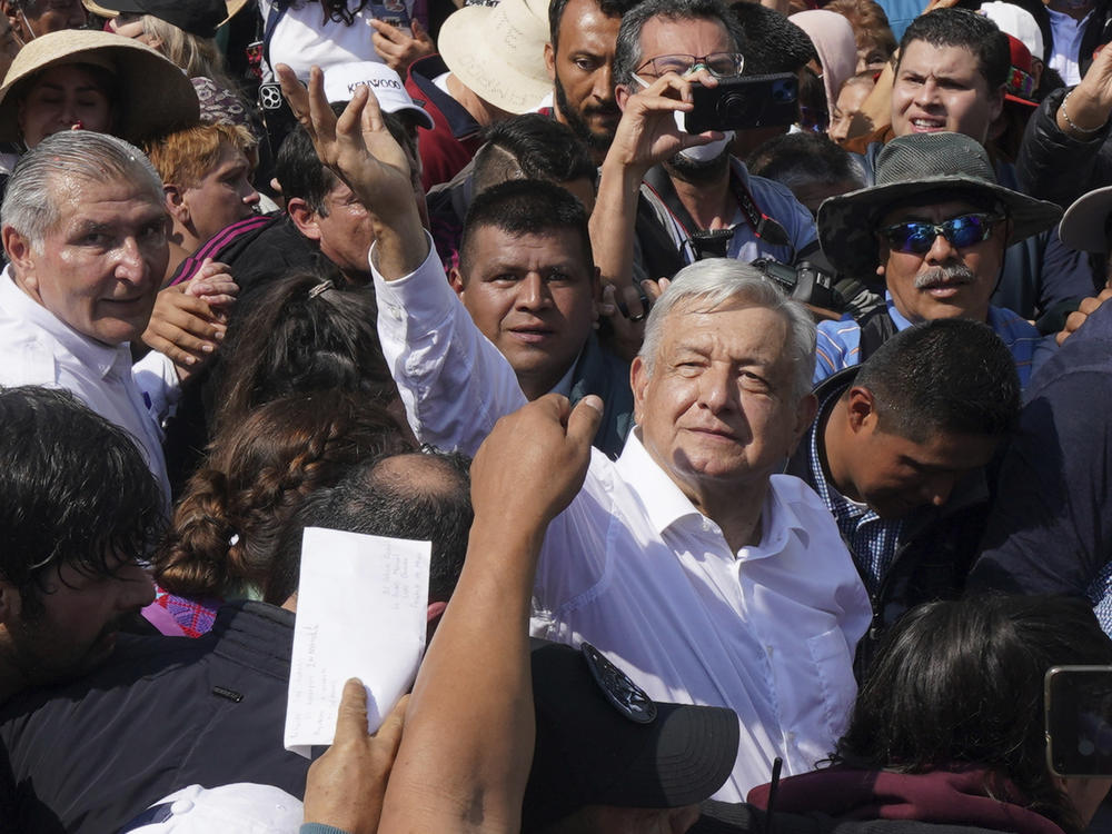 Mexican President Andrés Manuel López Obrador, right, waves during a march in support of his administration in Mexico City on Sunday.