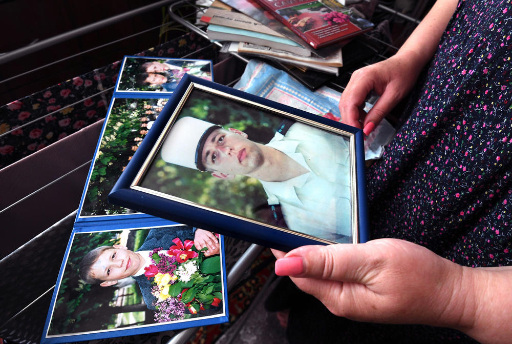 Oksana holds a photo of Oleksandr in his French Foreign Legion uniform.