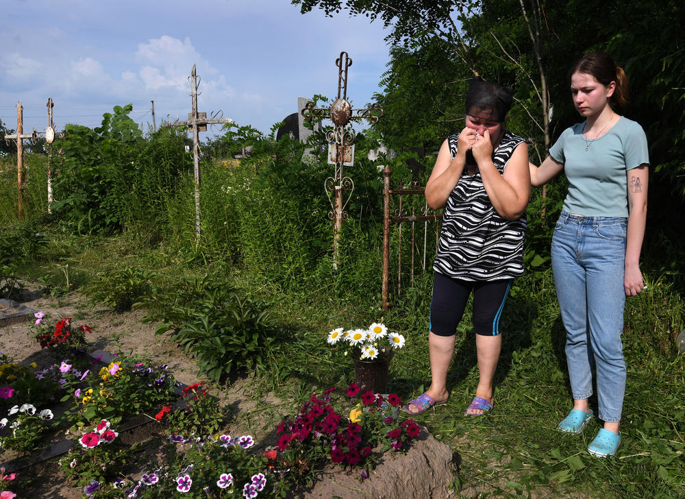 Oksana and Anya Breus visit Oleksandr's grave four months after he was killed.