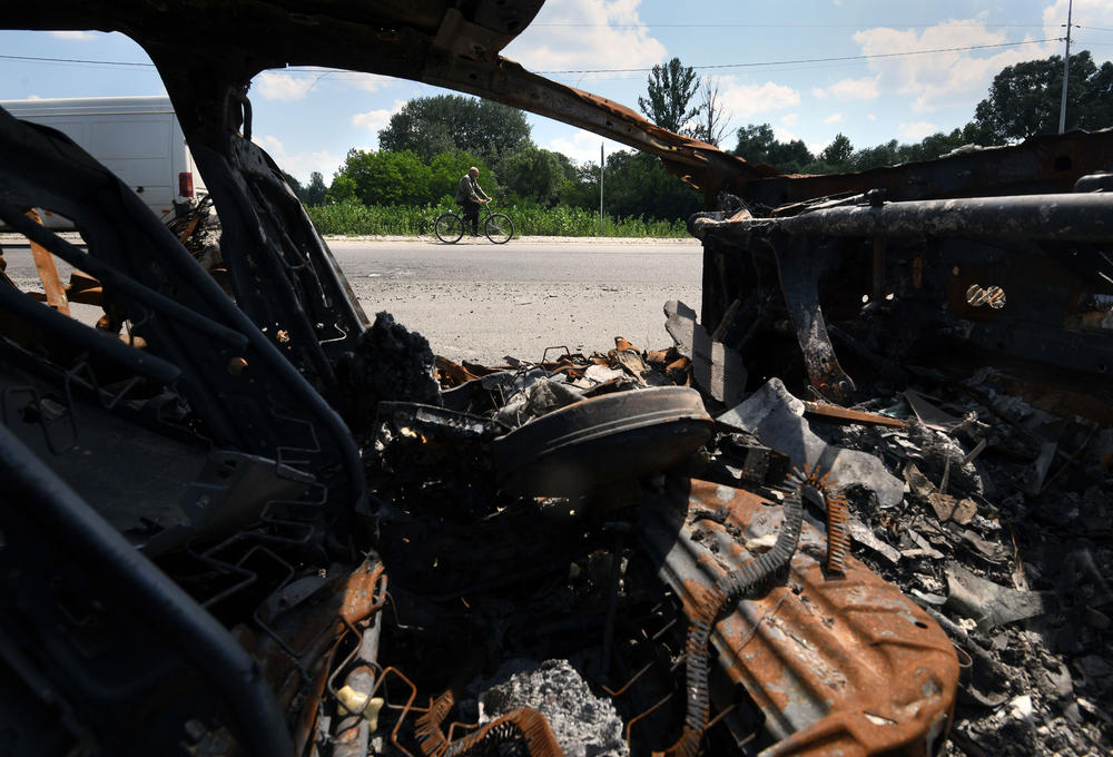 The charred remains of Oleksandr Breus' vehicle are parked on the side of the road in Nova Basan.