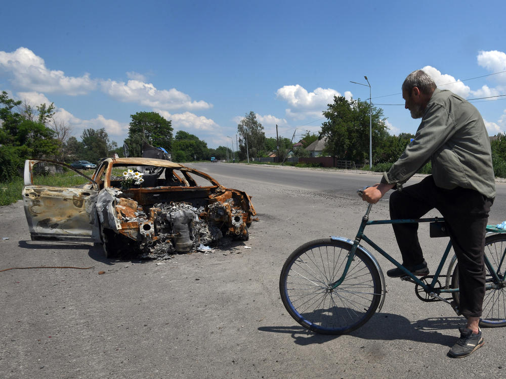 Oleksandr Breus, a Ukrainian and onetime French legionnaire, was killed next to his car during the Russian invasion. Oleksandr Holod, who says he witnessed it from his window, describes events as he rides his bike past the charred remains of the vehicle near Nova Basan, Chernihiv Oblast, Ukraine on June 28.