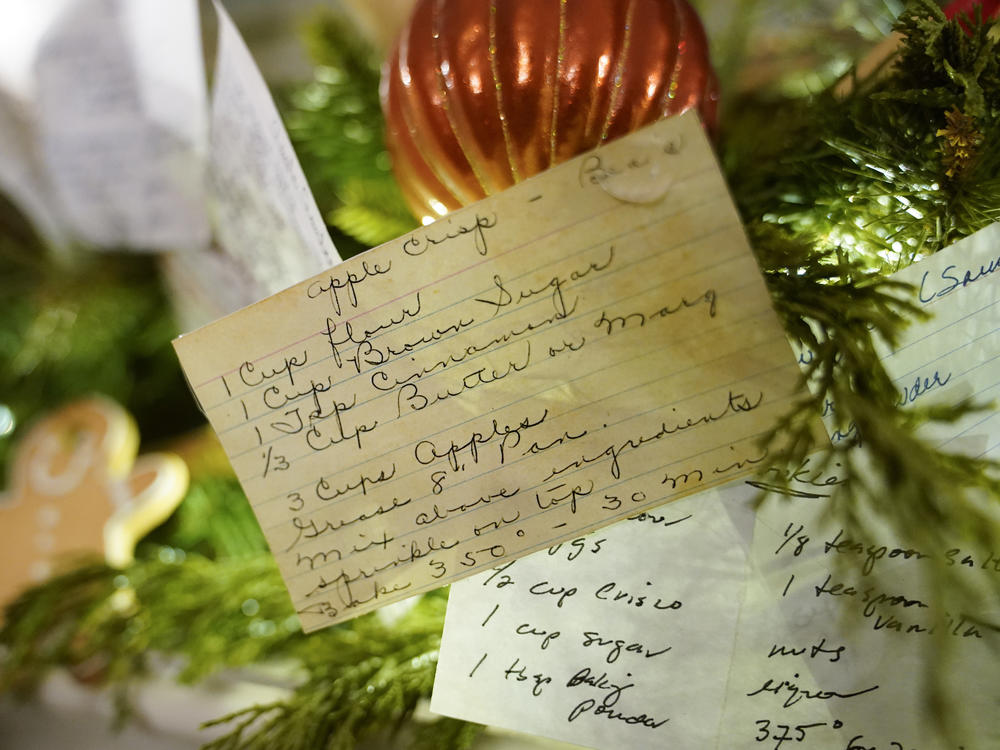 A copy of first lady Jill Biden's apple crisp recipe card is part of the decor on a fireplace mantel in the China Room. The White House says volunteers who helped decorate also contributed recipe cards on display.