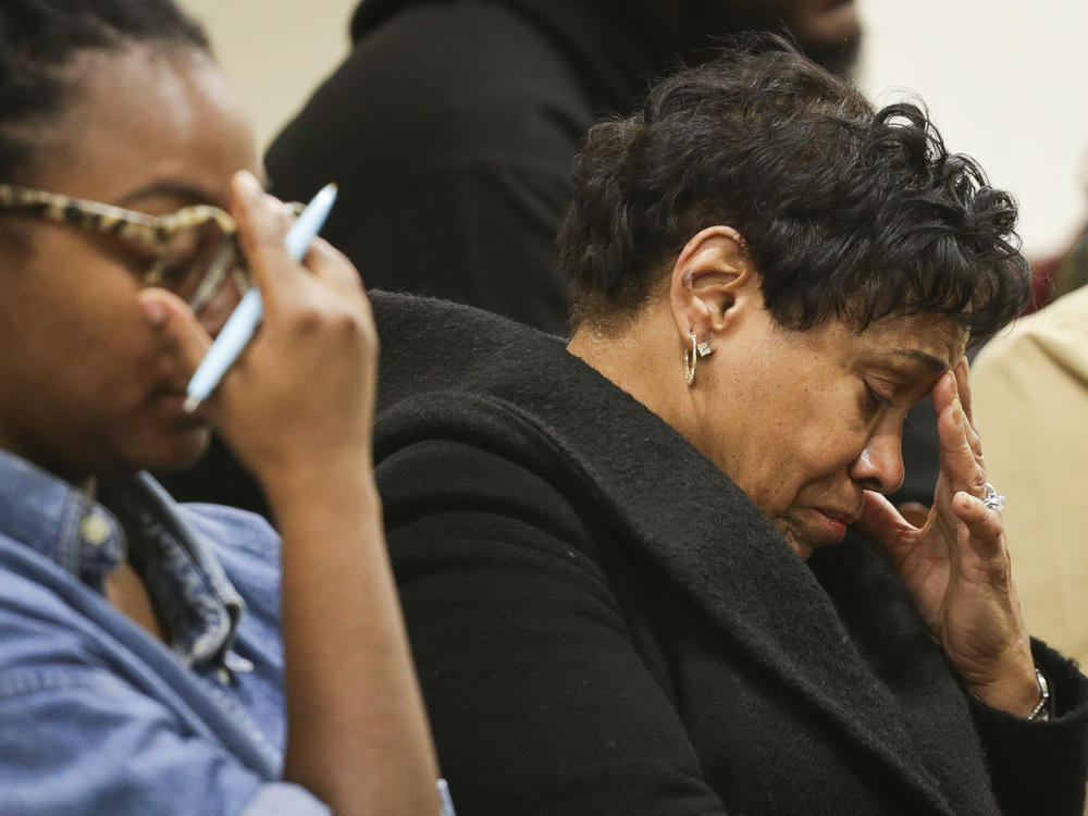 Family members of victims in the Topps supermarket shooting react as Erie County District Attorney John Flynn reads the names of victims during a press conference at Erie County Court, in Buffalo, N.Y. on Monday.