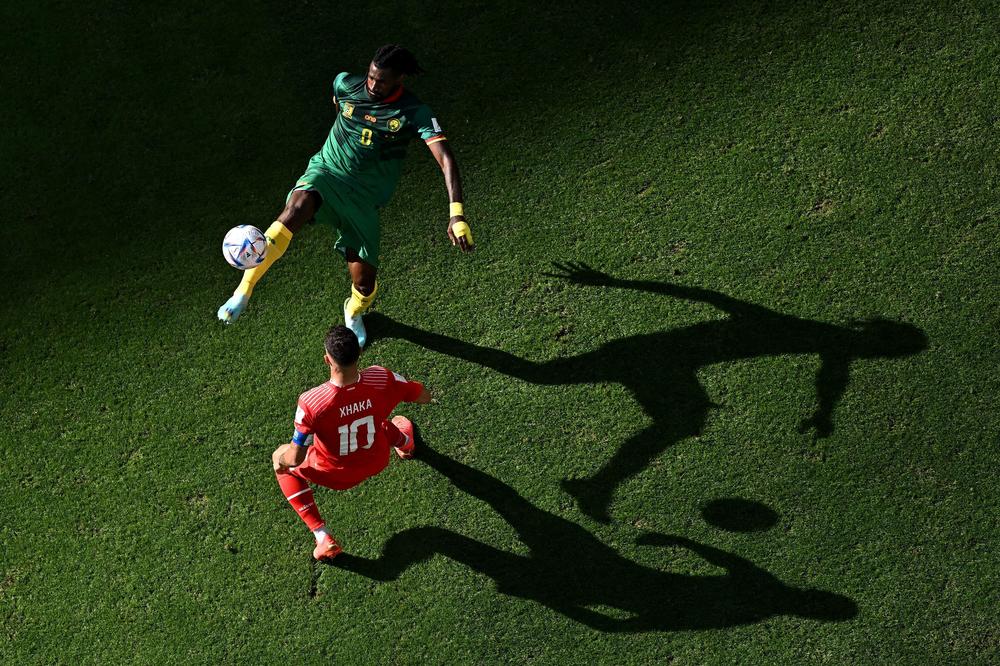 Cameroon midfielder Andre-Frank Zambo Anguissa (top, No. 8) fights for the ball with Switzerland midfielder Granit Xhaka (No. 10) during a 2022 World Cup Group G match on  Thursday, Nov. 24, 2022, at the Al-Janoub Stadium in Al-Wakrah, south of Doha, Qatar.