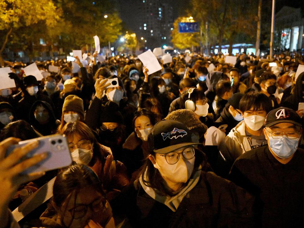 Protesters march in Beijing at a rally for the victims of a deadly fire as well as a protest against China's harsh COVID-19 restrictions early Monday.