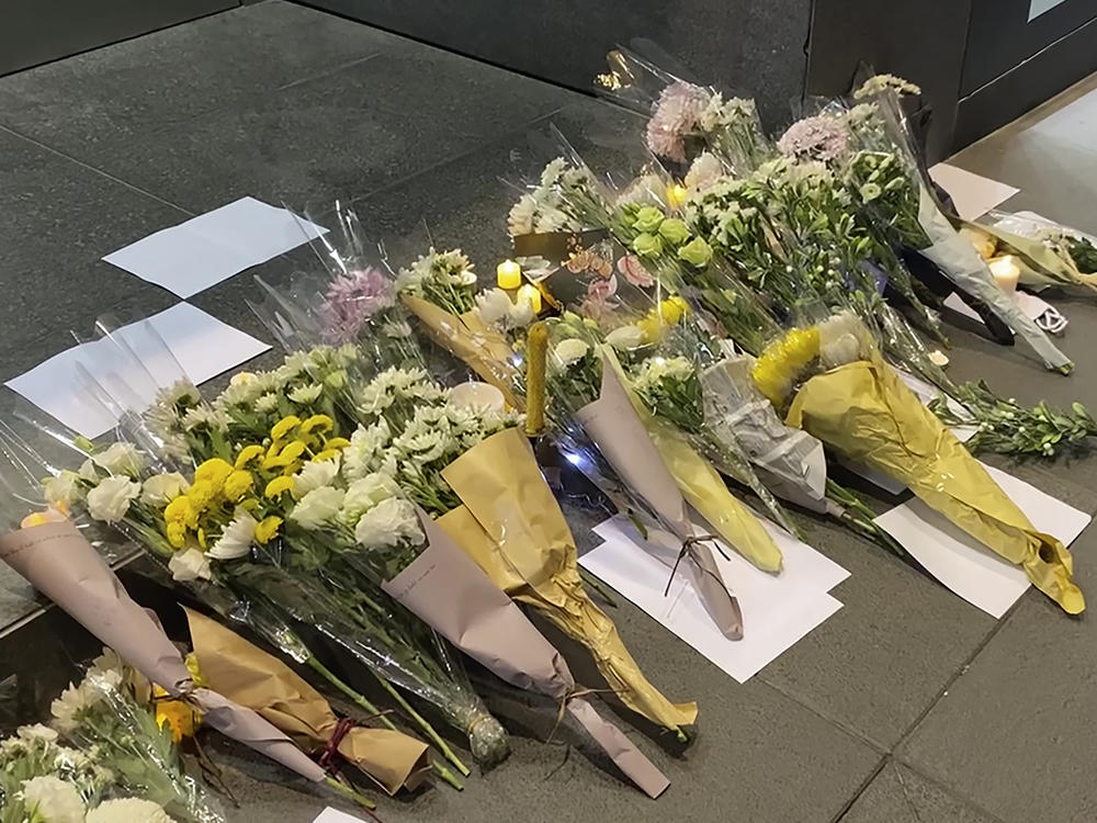 Blank white papers and flowers are laid down during a commemoration for victims of a recent Urumqi deadly fire in Central in Hong Kong, Monday, Nov. 28, 2022.