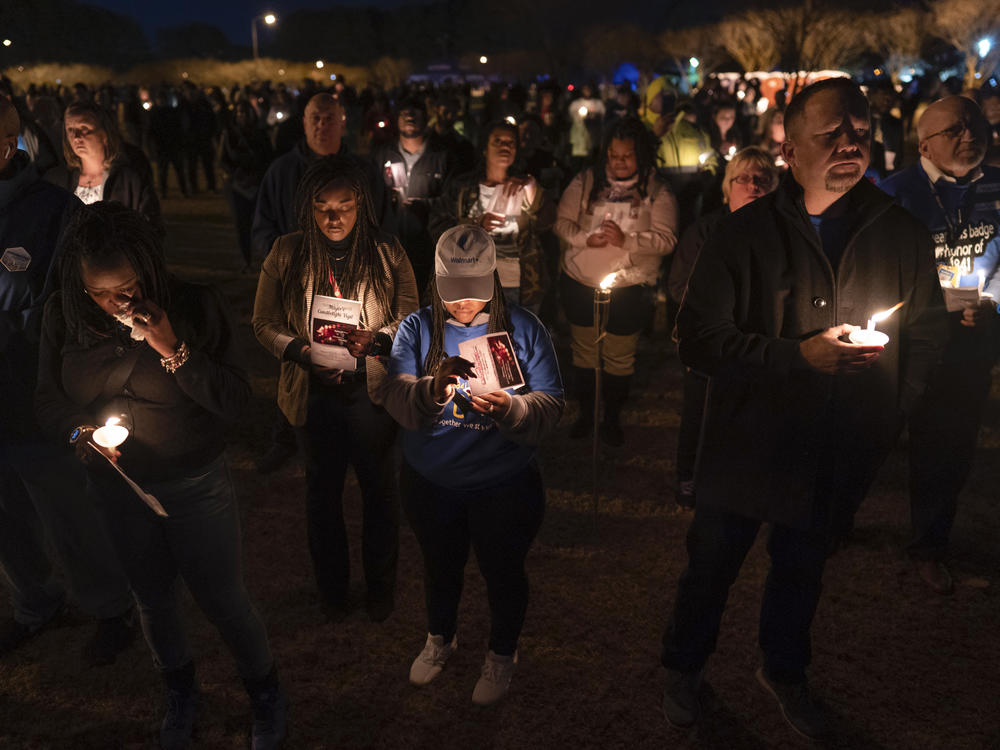 Community members, including Walmart employees, gather for a candlelight vigil at Chesapeake City Park in Chesapeake, Va., on Monday for the six people killed at a Walmart in Chesapeake, Va.