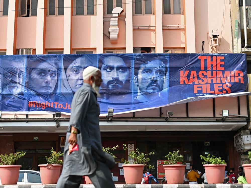 A man walks past a banner of Bollywood movie <em>The Kashmir Files</em> outside a cinema in the old quarters of Delhi on March 21, 2022.