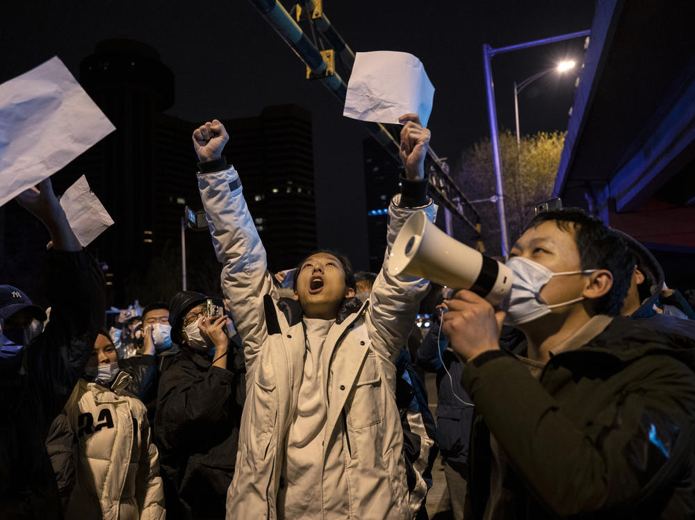 Protesters shout slogans during a protest against China's strict coronavirus measures on Monday in Beijing, China. Protesters took to the streets in multiple Chinese cities after a deadly apartment fire in Xinjiang province sparked a national outcry as many blamed COVID-19 restrictions for the deaths.