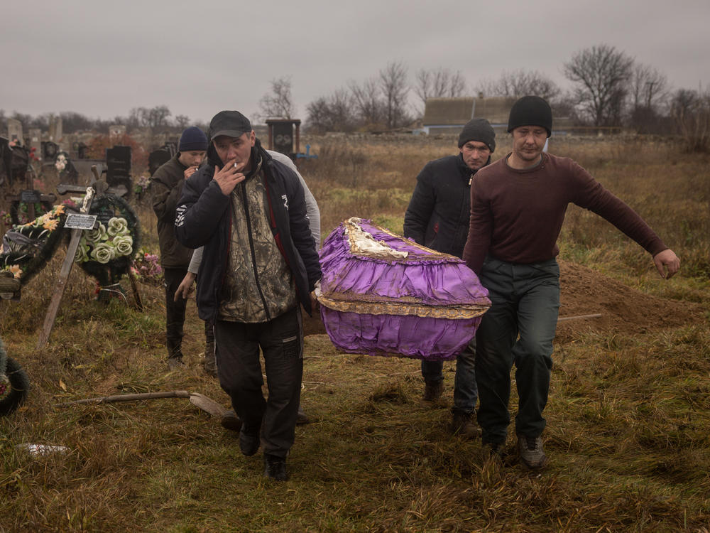 Residents of Kherson, Ukraine, carry the coffin of a 16-year-old girl on Nov. 29. The girl was killed by Russian forces.